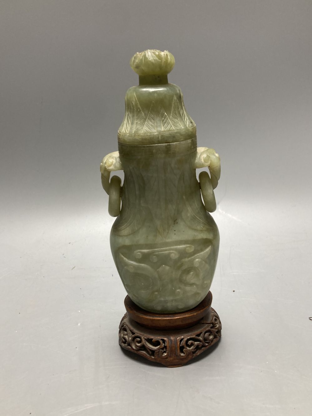 A 19th century Chinese blue and white double gourd shaped vase and cover and a green hardstone carved vase, cover and hardwood stand, t